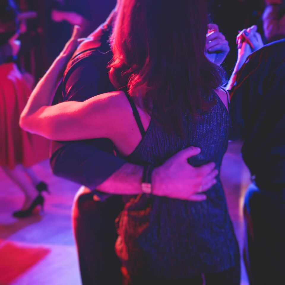 Couples dancing traditional latin argentinian dance milonga in the ballroom on a festival, tango studio, salsa, bachata and kizomba lesson in the red and purple lights, rehearsal in the dance class Couples dancing traditional latin argentinian dance milonga in the ballroom on a festival, tango studio, salsa, bachata and kizomba lesson in the red and purple lights, rehearsal in dance class